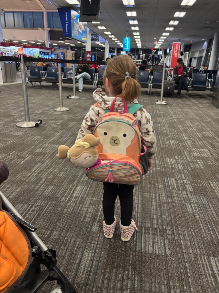 Toddler with her own packed luggage ready for travel